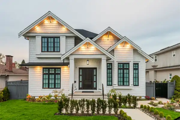 Modern home exterior with illuminated entryway, landscaped front yard, and contemporary architectural design, emphasizing electrical safety and home maintenance.