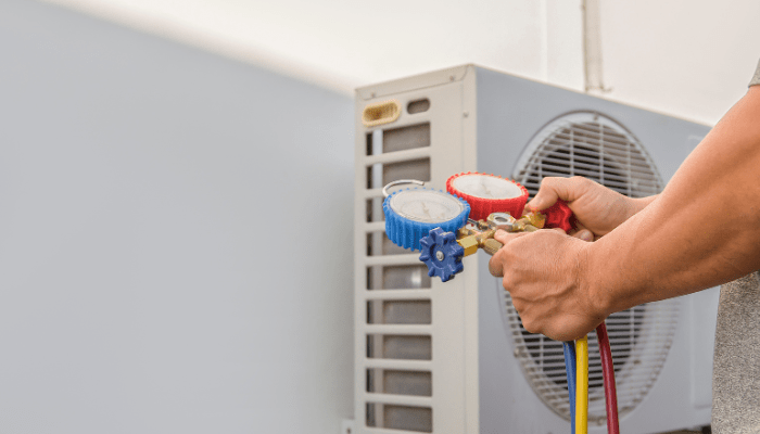 technician checking refrigerant levels of ac unit